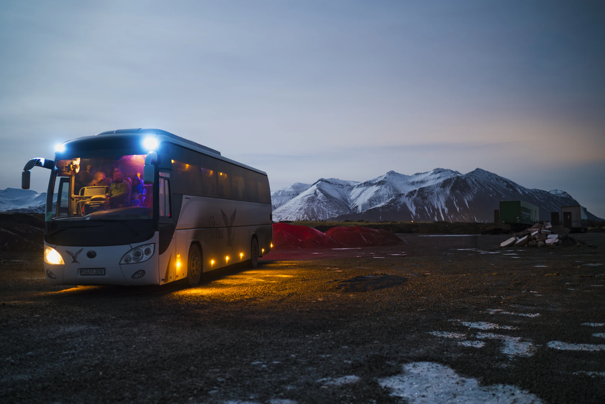 Autobus so zapnutými svetlami za skorého rána